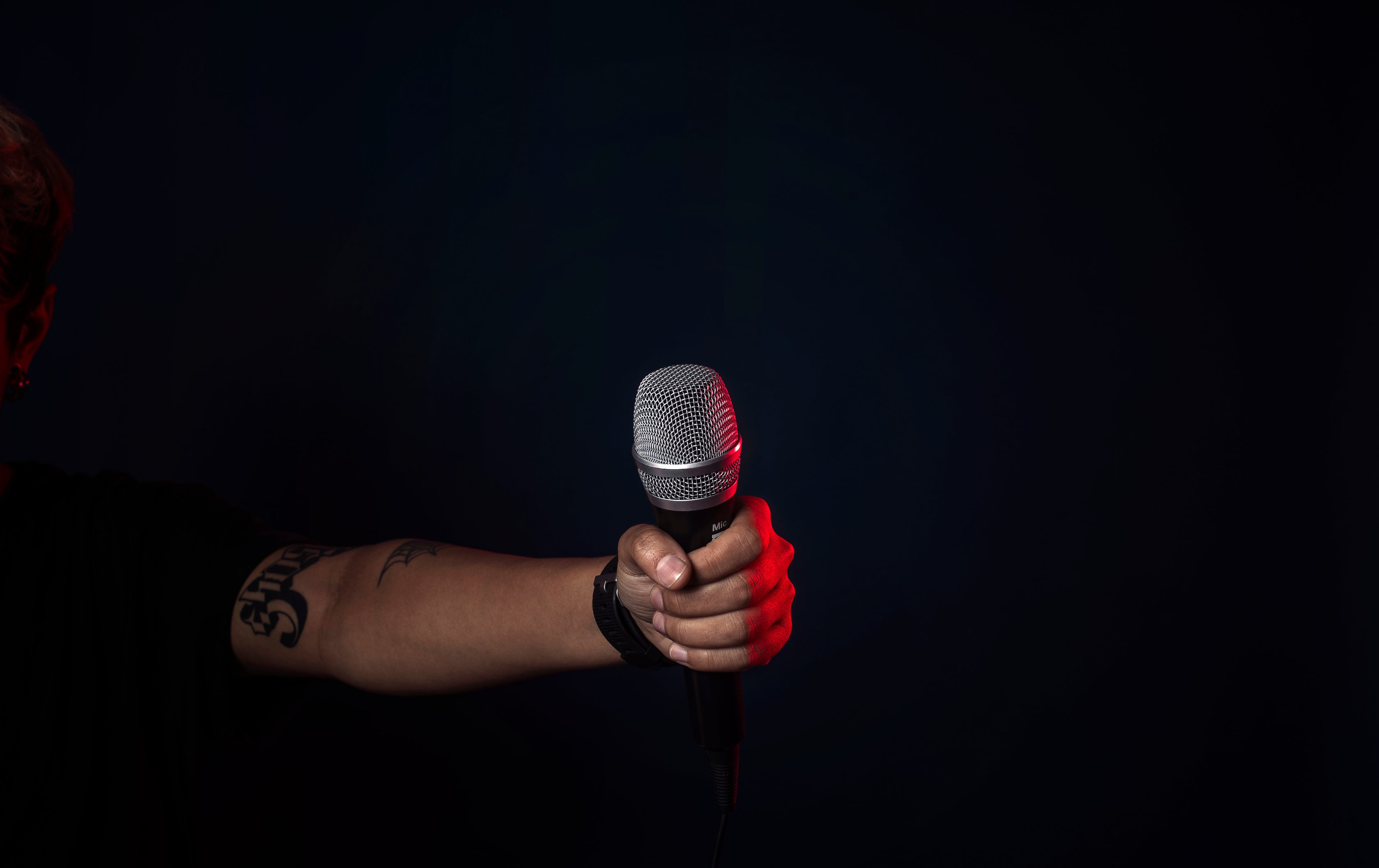 Singer holding microphone on stage – learn how to change song lyrics with AI Music Academy course