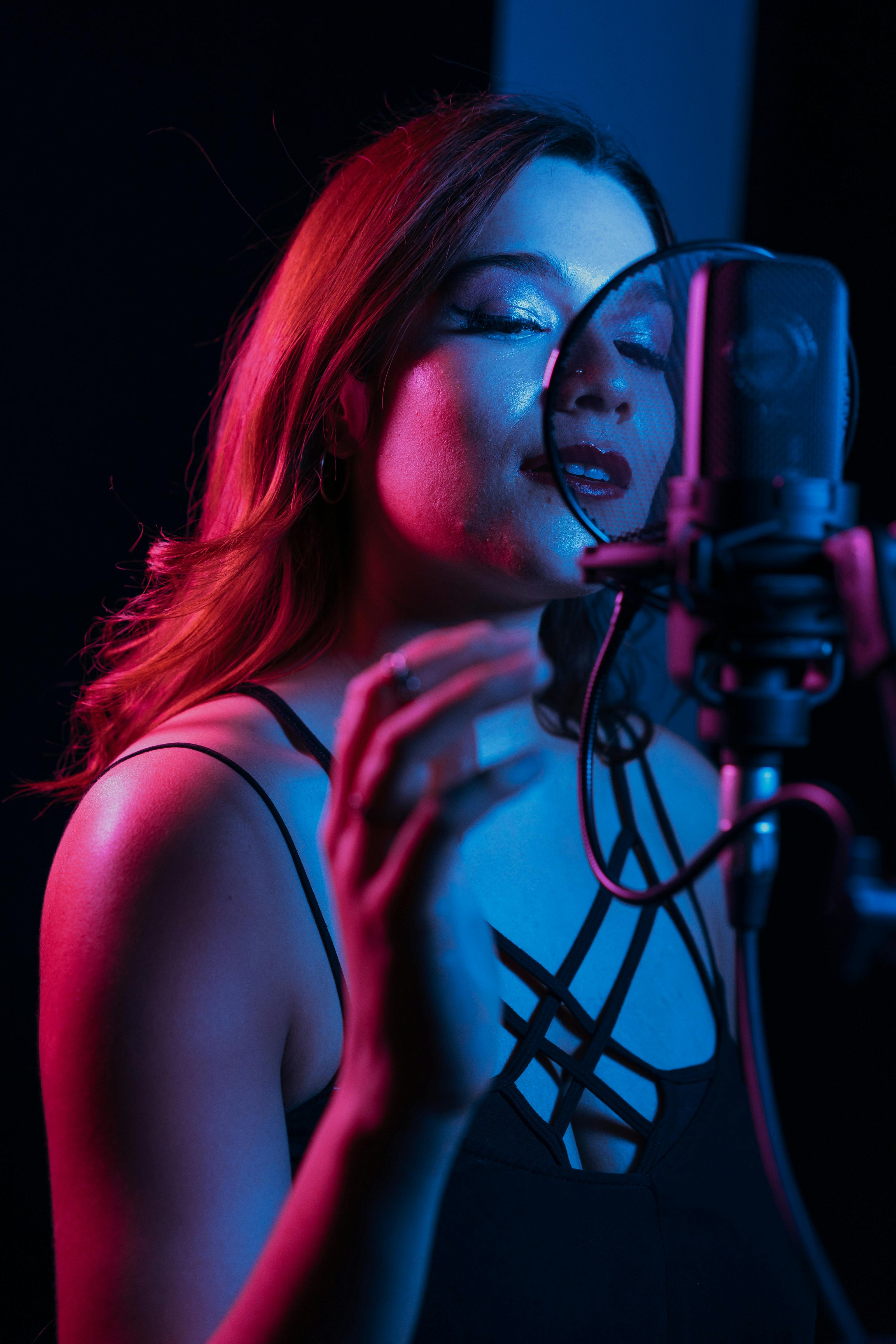 Female singer recording vocals in moody lighting – song lyric changer in action